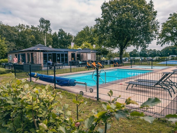 Relax by the pool surrounded by lush greenery and trees.