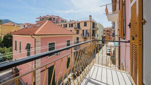 A balcony with yellow railings overlooking a street with parked cars and buildings. - Lovely apartment for 4 people with WIFI, TV and balcony (Sestri Levante)