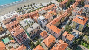 An aerial view of a coastal residential area with terracotta-roofed buildings, a beach, and a promenade with palm trees. - Lovely apartment for 4 people with WIFI, TV and balcony (Sestri Levante)