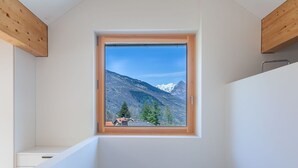 A room with a skylight window offering a mountain view.