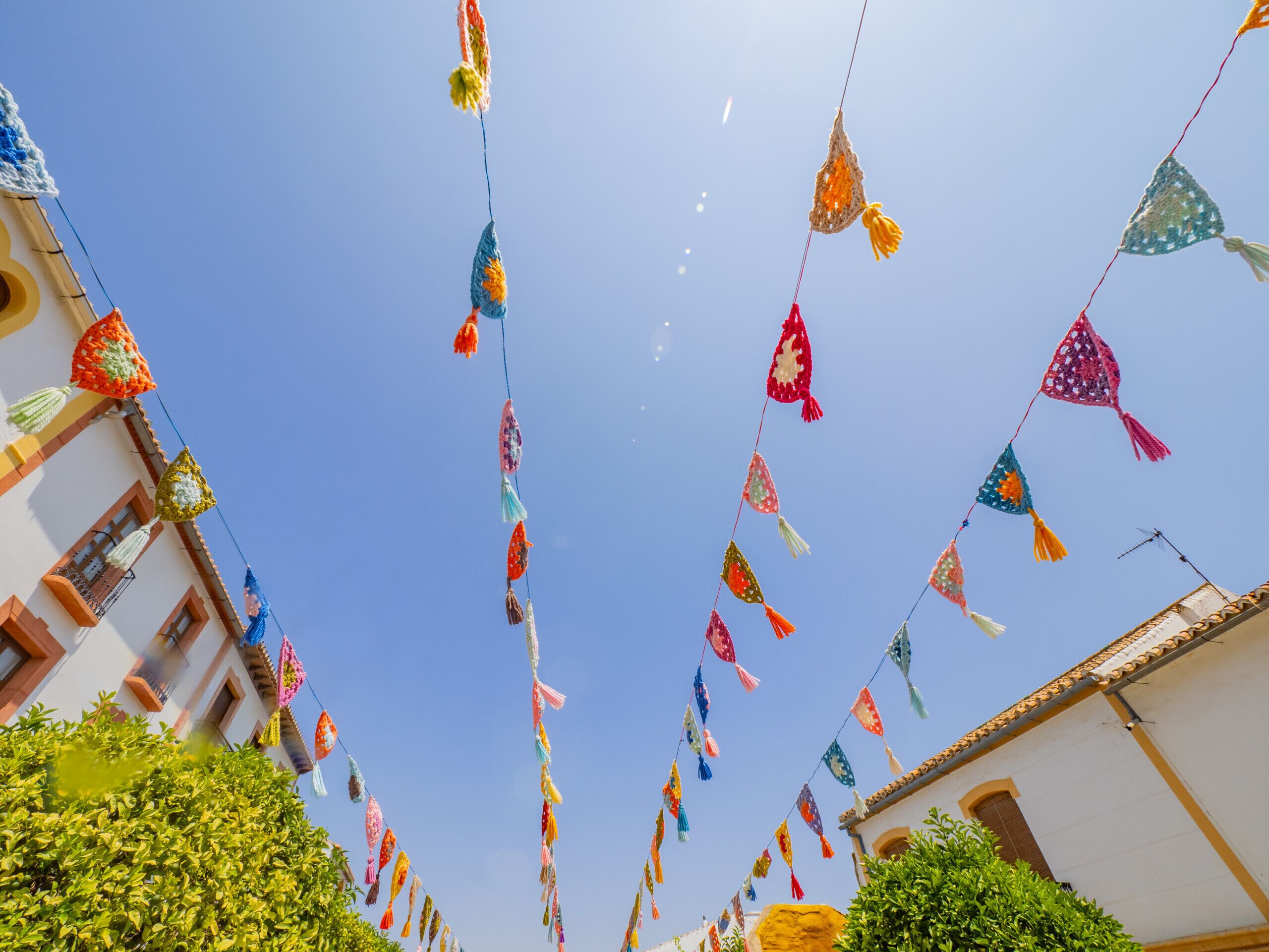 A street with colorful flags hanging between buildings.