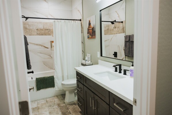 A bathroom with a bathtub, toilet, and a large mirror. - Cougar Canyon Unit C (Heber-Overgaard)