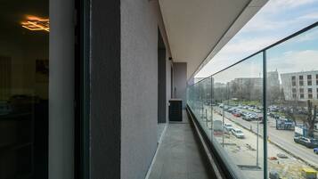 A balcony with a view of a busy street and buildings.