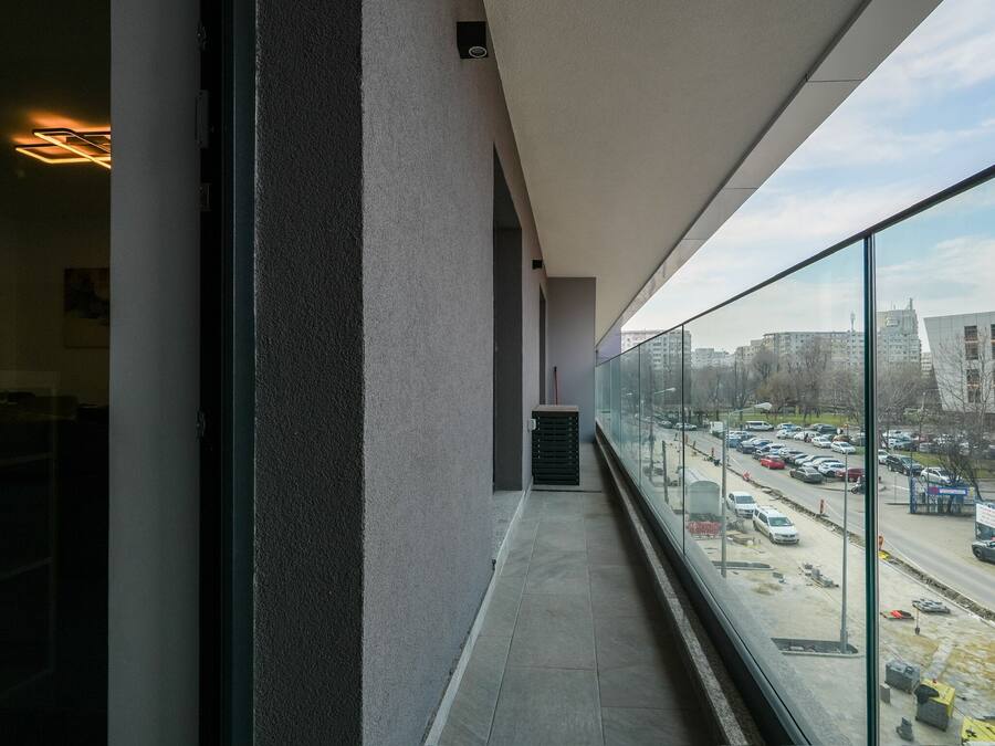 A balcony with a view of a busy street and buildings.