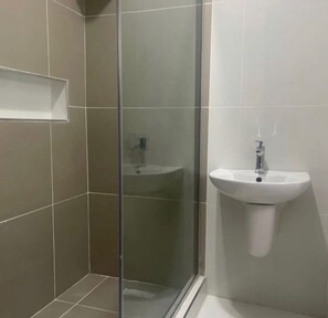 Regadera, toallas, jabón, papel de baño 
