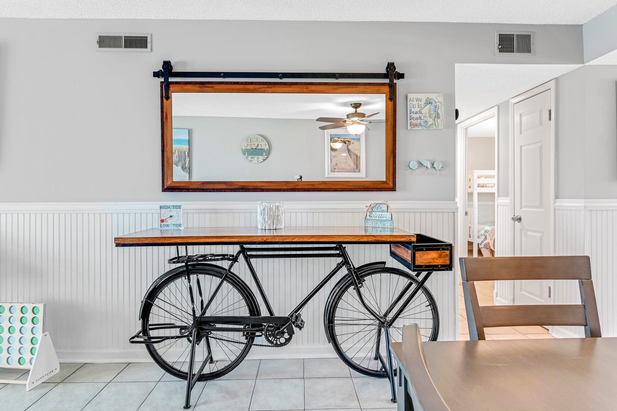 Un comedor con una mesa de madera, una bicicleta y un espejo en la pared.