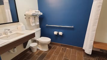 Un bagno con una parete blu, un WC bianco, un lavandino con uno specchio e una tenda da doccia.