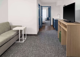 Suíte, 1 quarto | Área de estar | TV