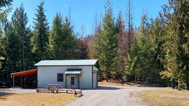 A small, single-story building with a green roof, a front door, and a small porch area. - Secluded & Private Getaway  (Priest River)