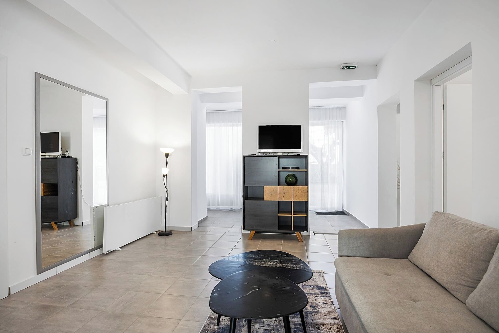 A modern living room with a sofa, a coffee table, a TV, and a cabinet.