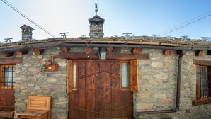 A rustic stone building with a wooden door, a bench, and a small window. - Lovely apartment for 4 people with WIFI, TV and pets allowed (Avise)