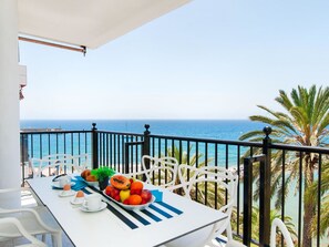Un balcón con una mesa lista para el desayuno, con vistas al mar.