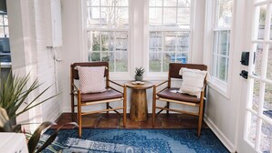 A cozy corner with two wooden chairs, a small round table, and a blue patterned rug. - Beautiful Spacious 4 BR Retreat in Uptown with Fire Pit & Porch (Martinsville)