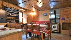 A rustic wooden interior with a dining area, wooden cabinets, and a fireplace. - Nice apartment for 4 people with WIFI, TV and pets allowed (Tartano)