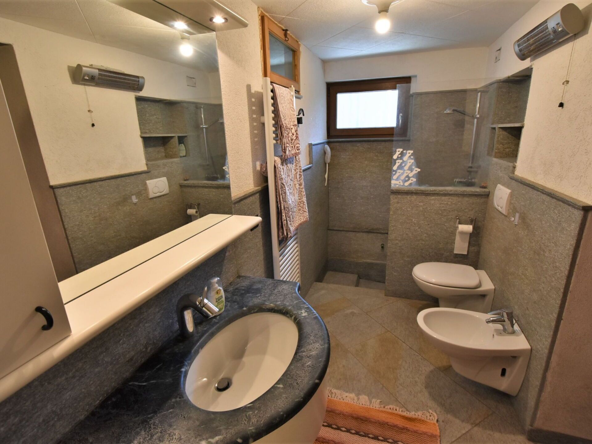 Une petite salle de bain comprenant un lavabo, des toilettes, un bidet et un miroir.