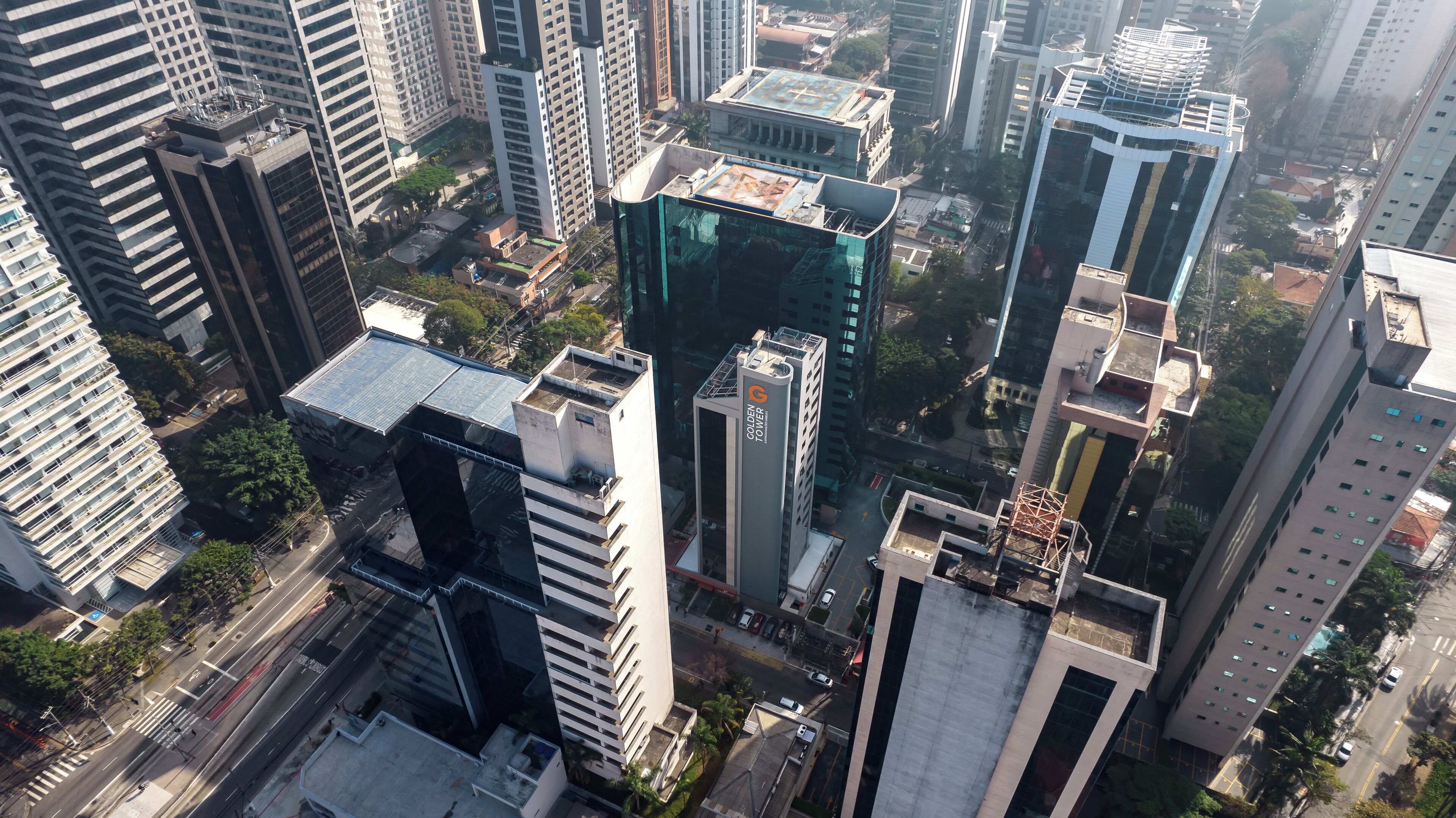 Un edificio alto con fachada moderna de vidrio, rodeado de otros edificios de gran altura.