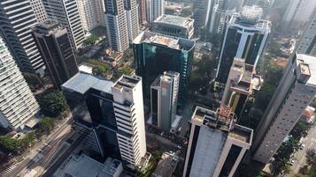 Un edificio alto con fachada moderna de vidrio, rodeado de otros edificios de gran altura.