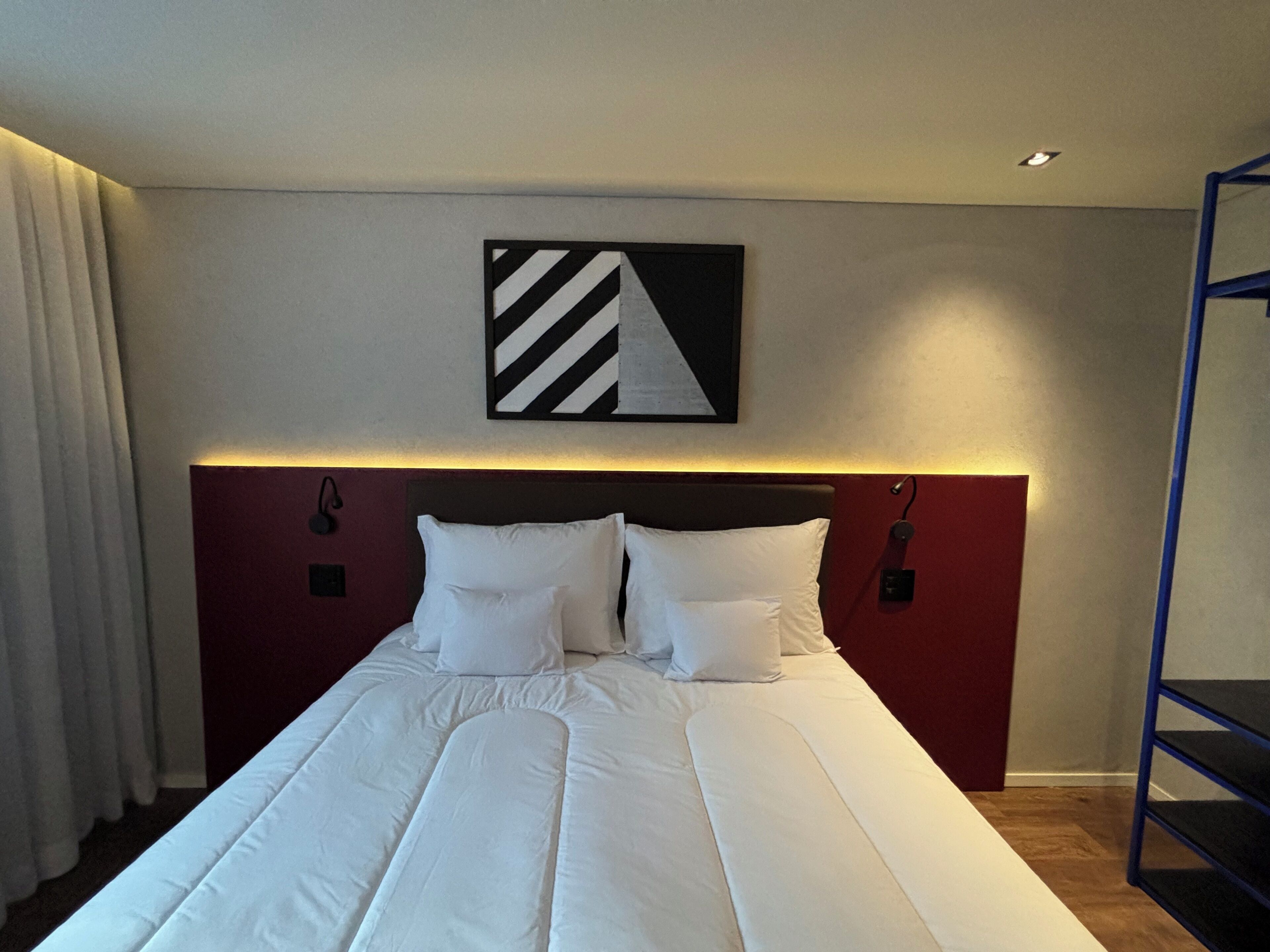 Una cama bien hecha con sábanas blancas en una habitación de hotel.