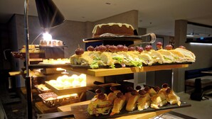 A buffet with various food items including sandwiches, cakes, and desserts. - Golden Tower Express Nações Unidas by Fênix Hotéis (São Paulo)