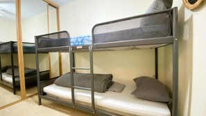 A bunk bed room with a mirror and a wooden wardrobe. - Apartamento Miramar Calpe (Calpe)