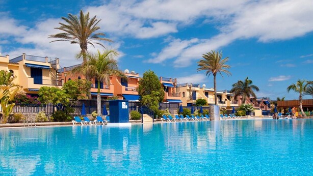 A clear blue pool surrounded by palm trees and a row of sun loungers. - Stunning private villa for 6 people with pool, A/C, WIFI, TV and patio (Maspalomas)