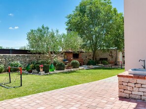 Escape to a serene outdoor oasis with lush greenery and a peaceful stone bench.