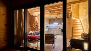 Ein modernes Blockhaus-Interieur mit einer gemütlichen Wohnbereitschaft, einer Küche und einem Essbereich.