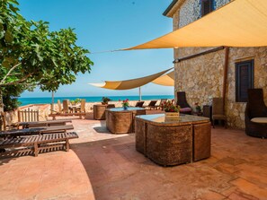 An outdoor seating area with wicker furniture, a storage box, and a view of the sea. - Beautiful apartment for 4 people with WIFI and TV (Balestrate-foce)