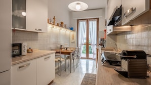 Una cocina moderna con comedor, horno empotrado, cafetera y parilla.
