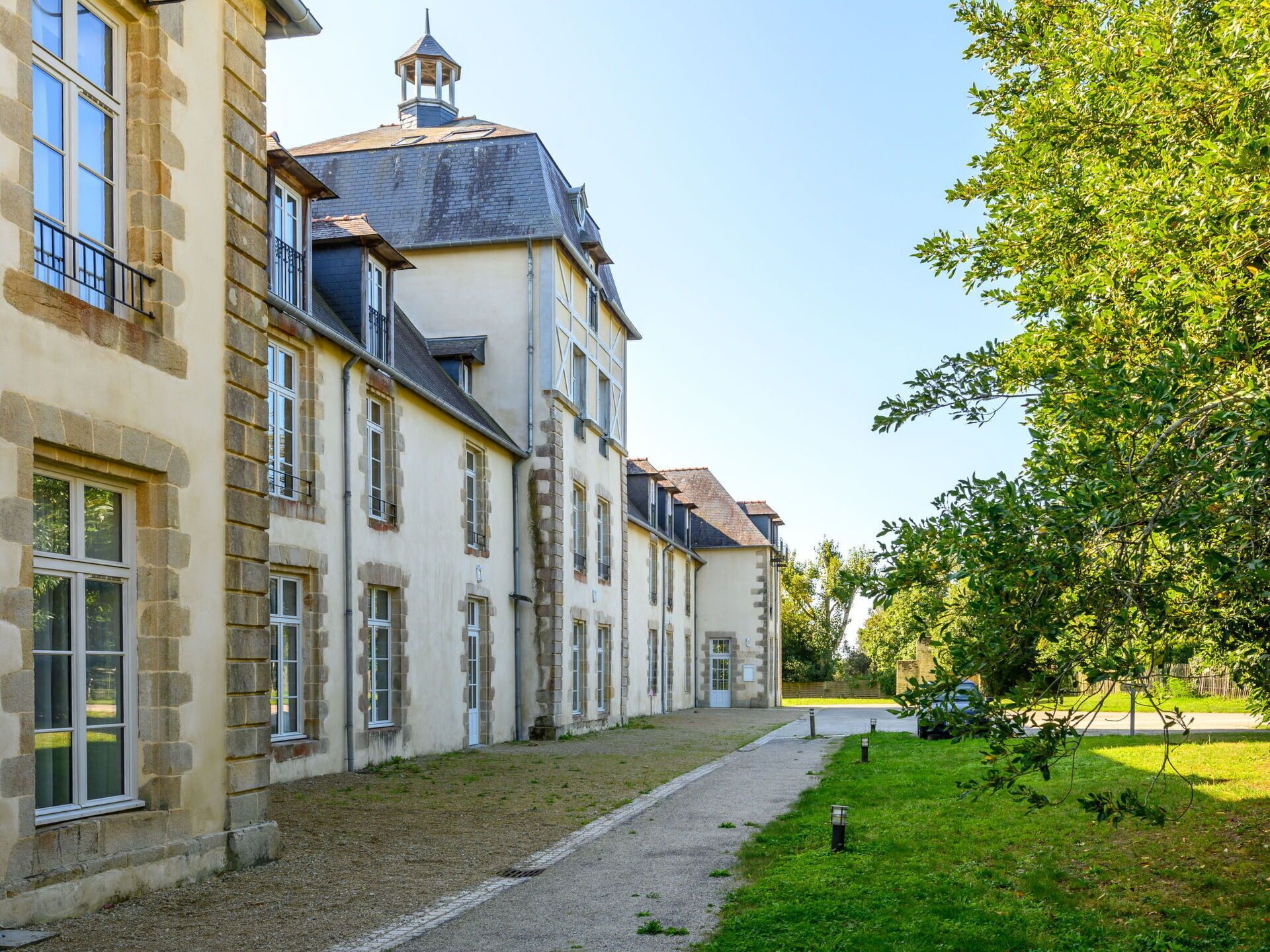 A historic building with a symmetrical facade, multiple windows, and a central tower.