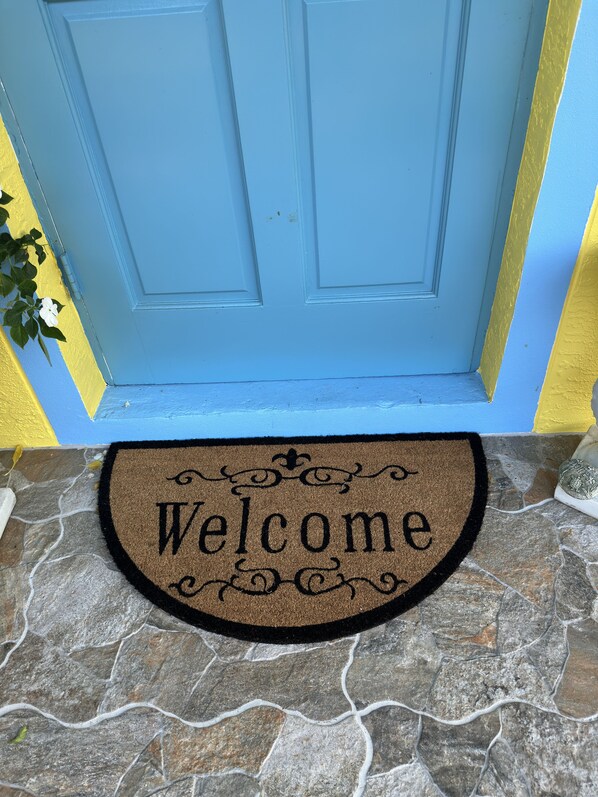 Una porta blu con un tappetino di benvenuto.