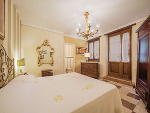 Classic design with a large bed, chandelier, and wooden wardrobe.