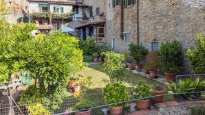 A courtyard with stone buildings, green shutters, and potted plants. - Nice apartment for 4 people with WIFI, A/C, pets allowed and panoramic view (Capannori)