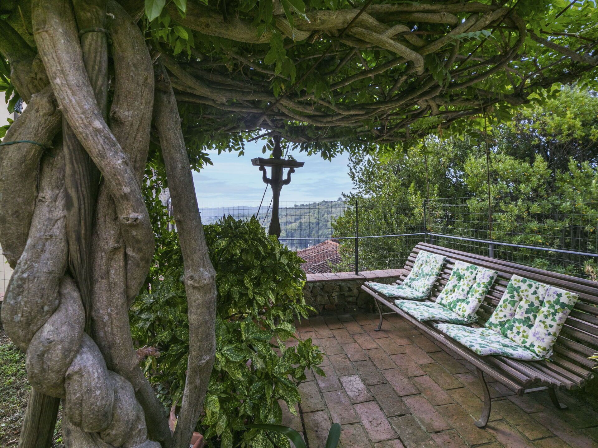 Un espace extérieur abrité, avec un banc et une vue sur le paysage.