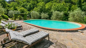 A swimming pool with lounge chairs and a stone patio. - Beautiful private villa for 8 guests with pool, A/C, WIFI, TV, patio and panoramic view (Greve In Chianti)