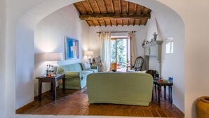 A cozy living room with a green sofa, a wooden coffee table, and a tiled floor. - Beautiful private villa for 8 guests with pool, A/C, WIFI, TV, patio and panoramic view (Greve In Chianti)