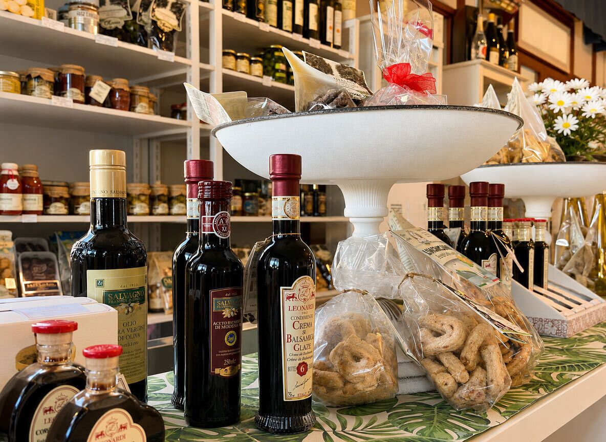 Variedad de botellas de aceite de oliva y aperitivos envasados sobre una encimera.