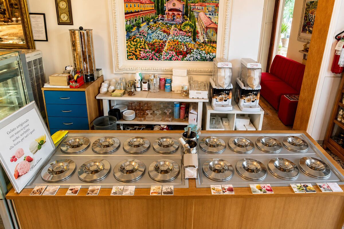 Eine Theke eines Cafés mit mehreren Servierpositionen, einer Kaffeemaschine sowie verschiedenen Gewürzen und Utensilien.