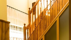 A wooden staircase with a handrail and a cushioned bench at the bottom. - Nice apartment for 10 people with private pool, WIFI, A/C, TV and balcony (Marcali)