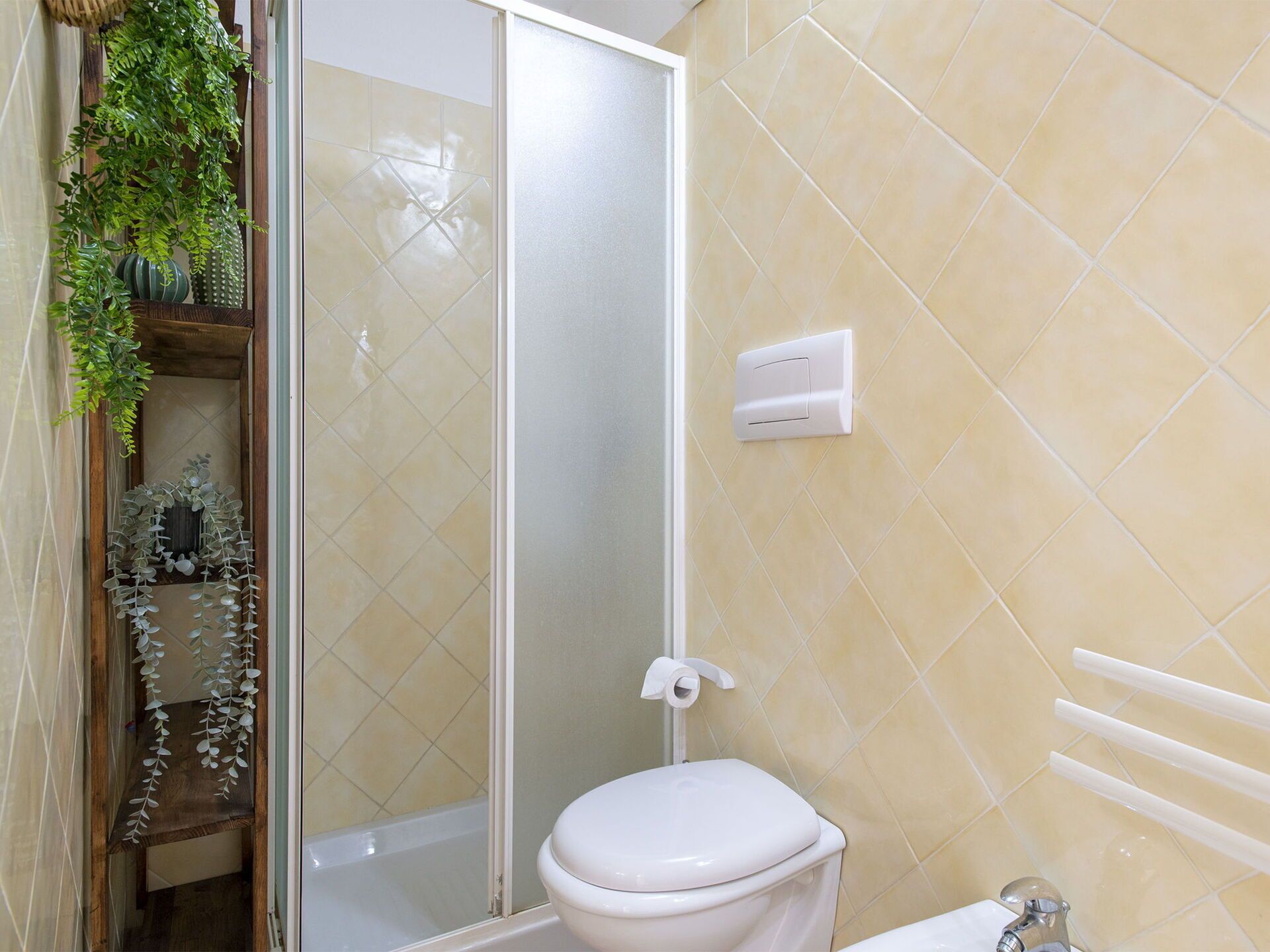 Une salle de bain équipée de toilettes, d’une douche et d’un porte-serviettes.