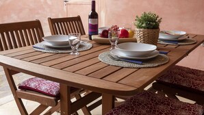 A wooden dining table set with plates, glasses, and a bottle of rosso wine. - Beautiful apartment for 5 people with A/C, TV and terrace (Regia Dogana)