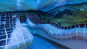 A spa area with a hot tub and a mural of a mountainous landscape.