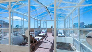 A glass-enclosed room with sun loungers and a small table, likely a sunroom or conservatory. - Beautiful private villa with WIFI, private pool, A/C, TV, patio, pets allowed and panoramic view (Montecatini)