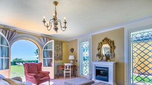 A spacious living room with a large window, a fireplace, and a red armchair. - Beautiful private villa with WIFI, private pool, A/C, TV, patio, pets allowed and panoramic view (Montecatini)