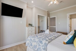 A bedroom with a bed, a dresser, a television, and a ceiling fan. - Unbeatable LOCATION, first row, Oceanfront! (Bolivar Peninsula)