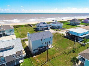 A coastal residential area with houses, a beach, and a clear sky. - Unbeatable LOCATION, first row, Oceanfront! (Bolivar Peninsula)