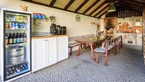 A rustic kitchen with a stone oven, wooden beams, a refrigerator stocked with beverages, and a dining area with a table and chairs. - Beautiful apartment for 4 people with WIFI, TV and terrace (Nový Bor)