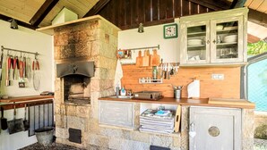 A rustic kitchen with a stone oven, wooden cabinets, and a stone floor. - Beautiful apartment for 4 people with WIFI, TV and terrace (Nový Bor)