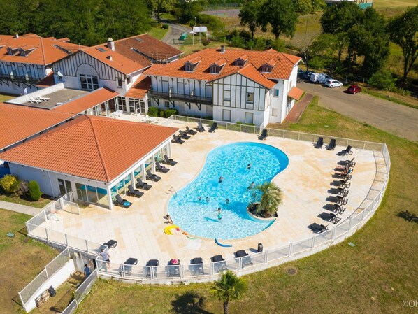 Relax by the oval-shaped pool surrounded by lounge chairs and sunbeds.