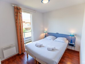 Relax in this inviting space with a large bed, two bedside tables, and a window with curtains.